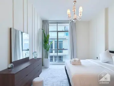 a white bedroom with a bed and a large window at Stylish Escape in Meydan 1B Polo Residence C3 in Dubai