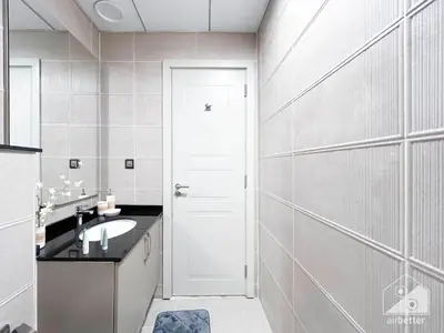 a bathroom with a sink and a white door at Stylish Escape in Meydan 1B Polo Residence C3 in Dubai