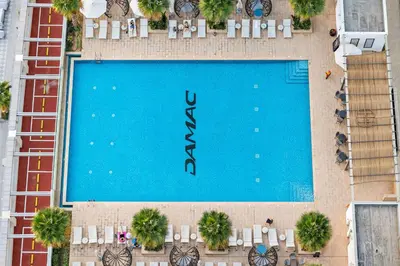an overhead view of a large swimming pool with tables and chairs at Vogue Business Bay Damac Maison Prive near Burj Khalifa and Dubai Mall, Studio Apartment with Canal and City View, Access to all Amenities in Dubai