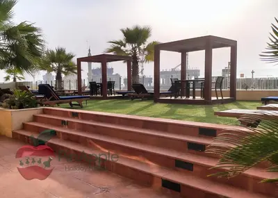 a patio with picnic tables and chairs on a roof at Sea and Dubai Ain view Close to Private Beach in Dubai