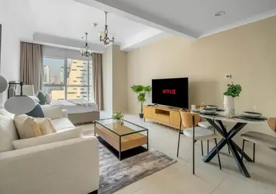 a living room with a couch and a table with a tv at Spectacular Studio & 1 Bedroom Units By Costa close to metro in Dubai