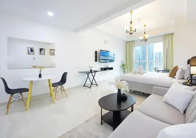 a white living room with a bed and a couch at Spectacular Studio & 1 Bedroom Units By Costa close to metro in Dubai