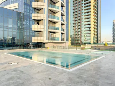 a swimming pool in front of a tall building at Studio Dubai, Cozy Luxury Stay Near Downtown Dining Shopping & Leisure in Dubai