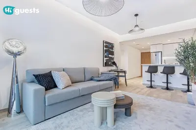 a living room with a couch and a kitchen at HiGuests - Modern & Stylish 1BR Apt - Near Business Bay Metro in Dubai
