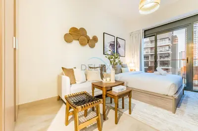 a bedroom with a bed and a couch and a table at City View Studio Minutes Drive to Burj Khalifa, Azizi Riviera 43, Al Merkadh by Deluxe Holiday Homes in Dubai