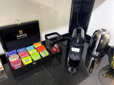 a coffeemaker and a coffee maker next to a coffee machine at Cozy 1BR with Canal View, Pool & Gym Access in Dubai