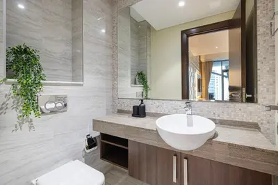 a bathroom with a sink and a mirror at Cozy 1BR with Canal View, Pool & Gym Access in Dubai
