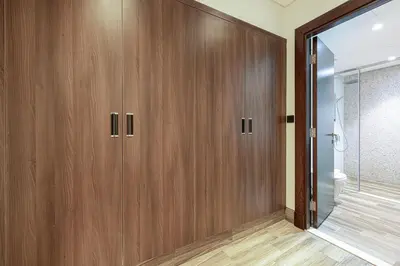 a bathroom with wooden cabinets and a shower at Cozy 1BR with Canal View, Pool & Gym Access in Dubai