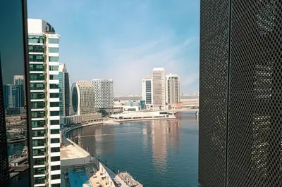 a view of a river in a city with buildings at Cozy 1BR with Canal View, Pool & Gym Access in Dubai