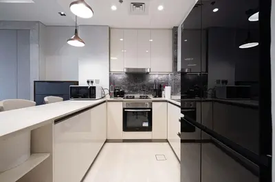 a kitchen with white cabinets and a stove top oven at Modern 1-Bedroom Apartment with Stunning Burj Khalifa and city Views in Dubai