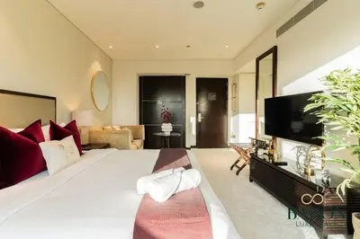 a large bedroom with a large bed and a television at The Captivating in Dubai