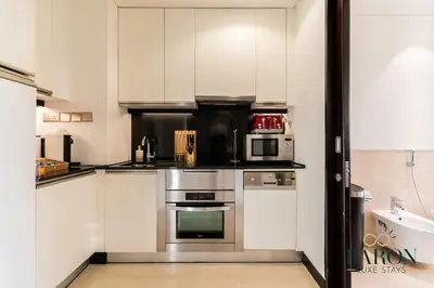 a kitchen with stainless steel appliances and white cabinets at The Captivating in Dubai