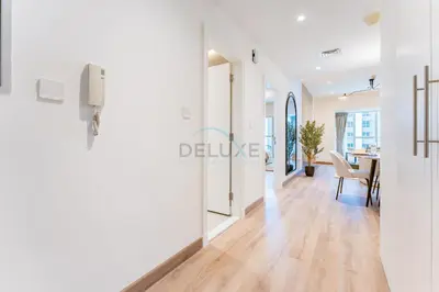 a hallway with white walls and a dining room with a table at Renovated Unit with Skyscraper Views, Close to JBR Beach, Elite Residence, Dubai Marina by Deluxe Holiday Homes in Dubai