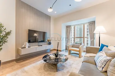 a living room with a couch and a tv at Renovated Unit with Skyscraper Views, Close to JBR Beach, Elite Residence, Dubai Marina by Deluxe Holiday Homes in Dubai