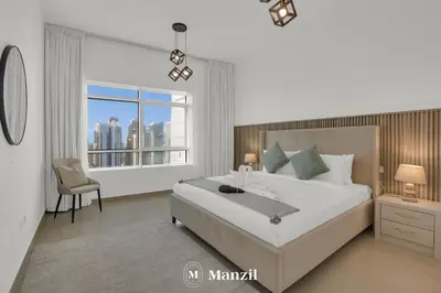 a white bedroom with a large bed and a window at 1BR Apartment in JLT 2km to JBR Beach & Blue Waters Dubai in Dubai