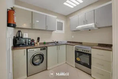 a kitchen with a washing machine and a washer at 1BR Apartment in JLT 2km to JBR Beach & Blue Waters Dubai in Dubai