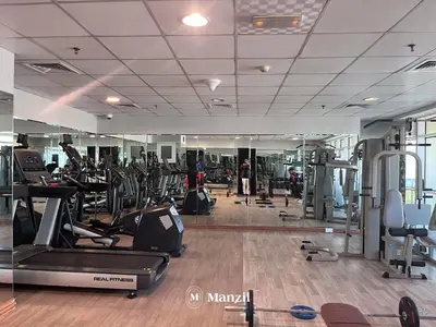a gym with treadmills and ellipticals and a mirror at 1BR Apartment in JLT 2km to JBR Beach & Blue Waters Dubai in Dubai