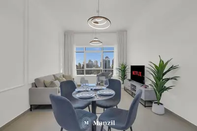 a living room with a table and chairs and a couch at 1BR Apartment in JLT 2km to JBR Beach & Blue Waters Dubai in Dubai