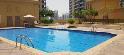a large blue swimming pool in a building at High Floor 2BR With a View of the Dubai Marina Canal Steps Away From the Beach , Shams 1, JBR by Deluxe Holiday Homes in Dubai