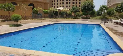 a large blue swimming pool in a building at High Floor 2BR With a View of the Dubai Marina Canal Steps Away From the Beach , Shams 1, JBR by Deluxe Holiday Homes in Dubai