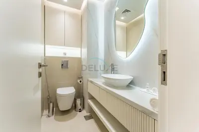 a bathroom with a sink and a toilet and a mirror at Refurbished 1BR High-Floor Unit with Partial City & Sea Views, Walking Distance to the Beach, Elite Residence, Dubai Marina by Deluxe Holiday Homes in Dubai