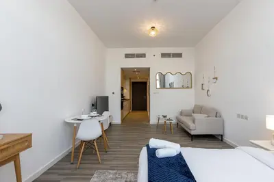 a living room with a bed and a couch and a table at Upgraded Brand New Studio in Belgravia 2, JVC - Allsopp & Allsopp in Dubai