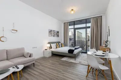 a living room with a couch and a table at Upgraded Brand New Studio in Belgravia 2, JVC - Allsopp & Allsopp in Dubai