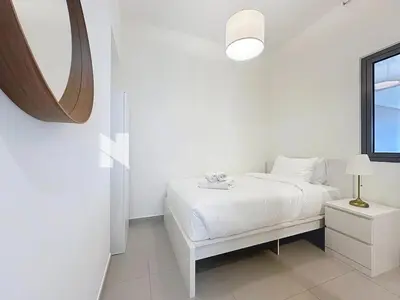 a white bedroom with a white bed and a mirror at Modern Five Bedroom Villa with BBQ and Garden in Dubai