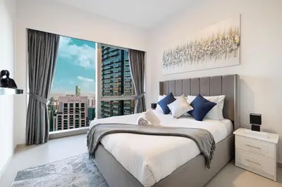 a bedroom with a large bed and a large window at Stay in the #1 Burj & Fountain View 4BR Apartment in Dubai