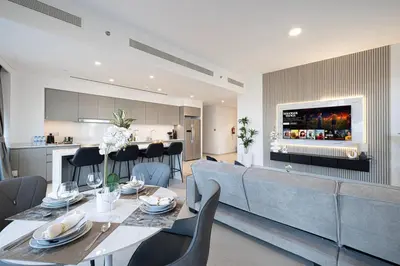 a living room and kitchen with a table and chairs at Stay in the #1 Burj & Fountain View 4BR Apartment in Dubai