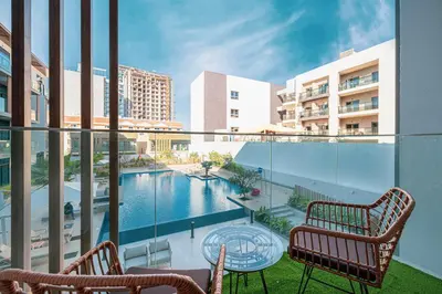 a balcony with two chairs and a swimming pool at Modern & Luxurious Studio - Near CircleMall in Dubai