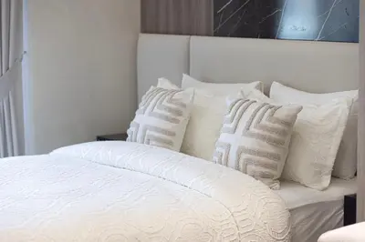 a white bed with a bunch of pillows on it at Modern & Luxurious Studio - Near CircleMall in Dubai