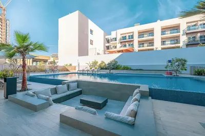 a swimming pool with couches and a building at Modern & Luxurious Studio - Near CircleMall in Dubai