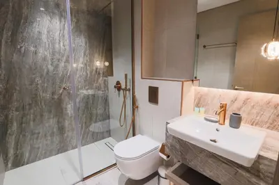 a bathroom with a sink and a shower and a toilet at Elegant 1BR in JVC in Dubai