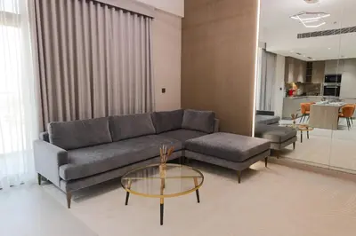 a living room with a couch and a table at Elegant 1BR in JVC in Dubai