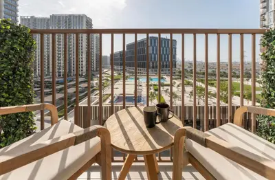 a table on a balcony with a view of a city at 2 bedroom apartment Dubai Hills in Dubai