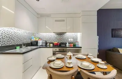 a kitchen with a table and chairs in a room at Luxury 2BR above the clouds on38 in Dubai