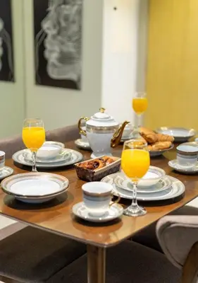a wooden table with plates and glasses of orange juice at Luxury 2BR above the clouds on38 in Dubai