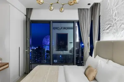 a bedroom with a large window with a city skyline at Novity Signature Homes in Dubai