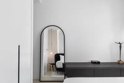 a mirror in a room with a black chair at Novity Signature Homes in Dubai