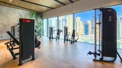 a gym with cardio equipment and a view of the city at Novity Signature Homes in Dubai