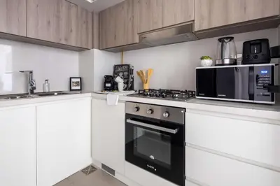 a kitchen with a stove and a microwave at Frank Porter - Prive Residence in Dubai