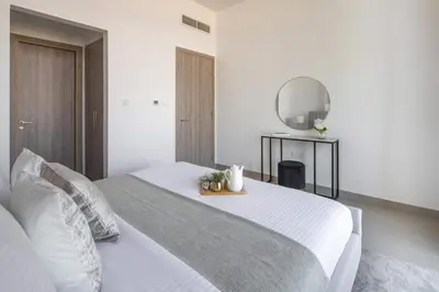 a bedroom with a white bed and a mirror at Frank Porter - Prive Residence in Dubai