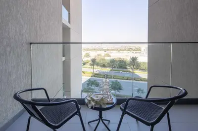 a balcony with two chairs and a glass table at Frank Porter - Prive Residence in Dubai