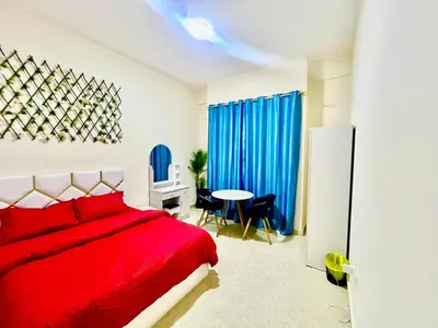 a bedroom with a red bed and a table at Haifa building in Dubai