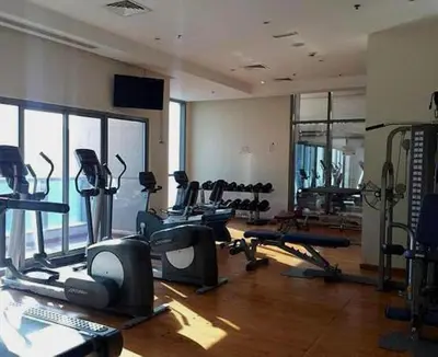 a gym with several treadmills and machines in a room at Big Studio Apartment in Dubai Marina Walking to JBR Beach, Cruise and DMCC Metro in Dubai
