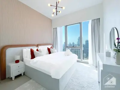 a bedroom with a white bed with a large window at Luxury 1BR at Grande Downtown with Iconic Views in Dubai