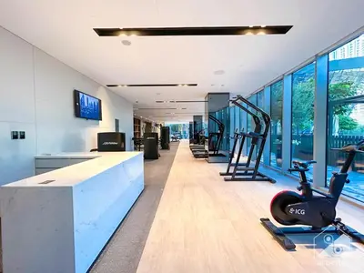 an office with a gym with exercise equipment and windows at Luxury 1BR at Grande Downtown with Iconic Views in Dubai