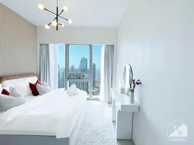 a white bedroom with a white bed and a mirror at Luxury 1BR at Grande Downtown with Iconic Views in Dubai