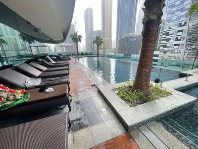 a pool with a palm tree in a city at Unmatched luxury perfectly located next to Dubai Mall and Burj Khalifa in Dubai